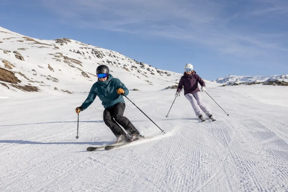 Dos adultos esquiando en Sierra Nevada con seguridad a su propio ritmo